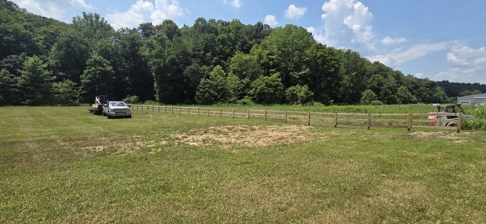 Three-board wood fence along a field